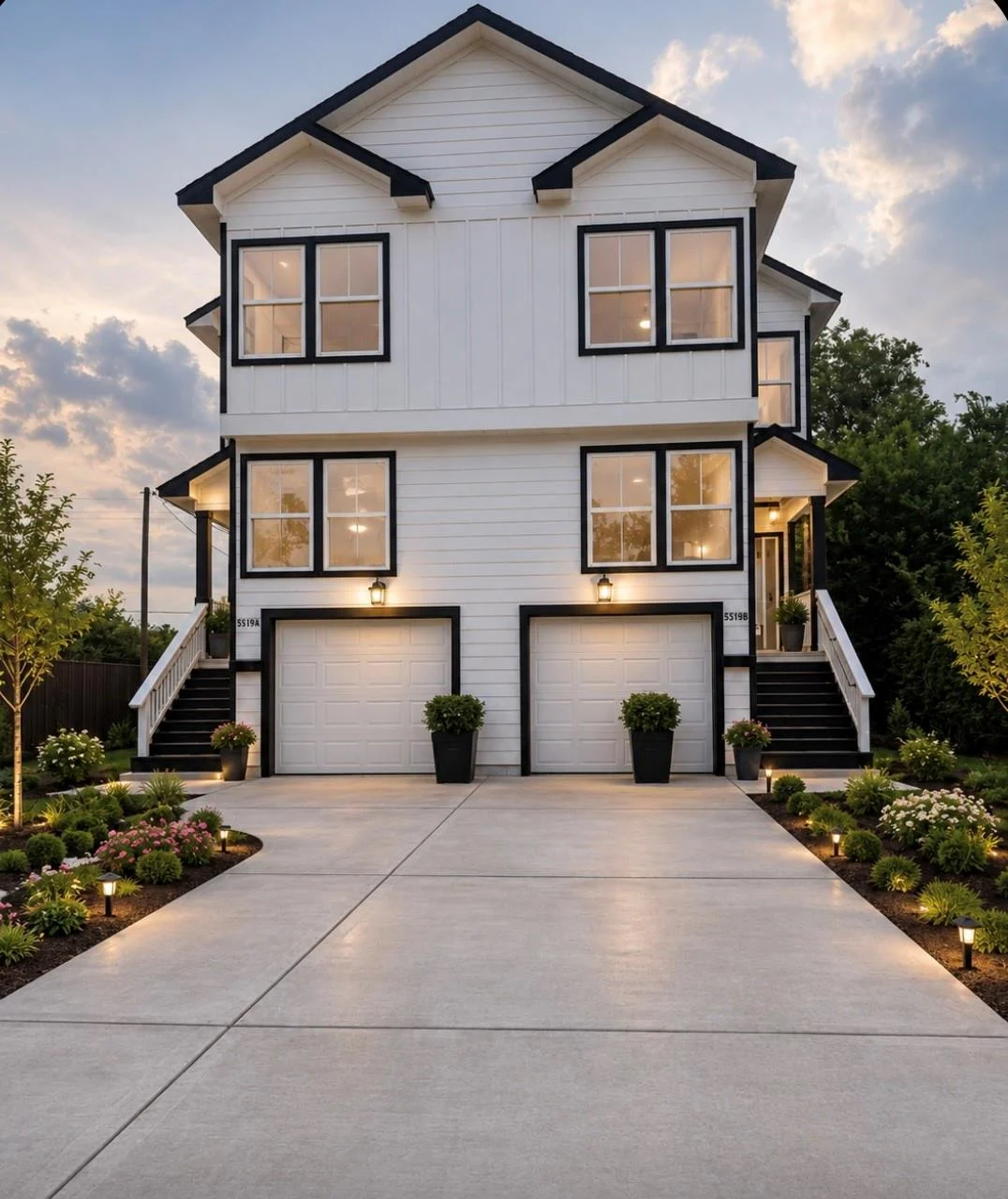 Two-story white home with black trim, lit windows and a wide driveway at The Better Half Living Homes